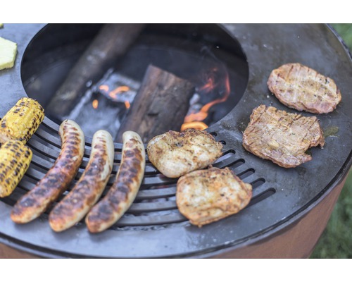 Barbecue avec saucisses, épis de maïs et viande sur feu ouvert