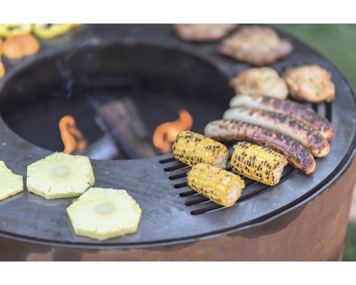 Barbecue avec viande, saucisses, maïs et ananas au-dessus du feu