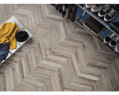 Intérieur avec carrelage imitation bois et motif à chevrons, portant à vêtements et vêtements