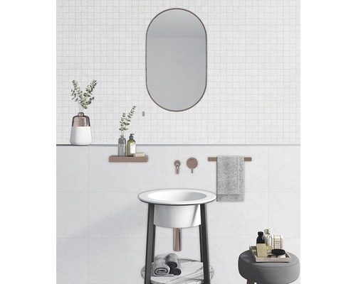 Helles Badezimmer mit Waschbecken, Spiegel und Ablageflächen.