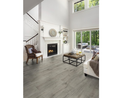 Heller Wohnraum mit Kamin, Treppe und grauem Holzboden