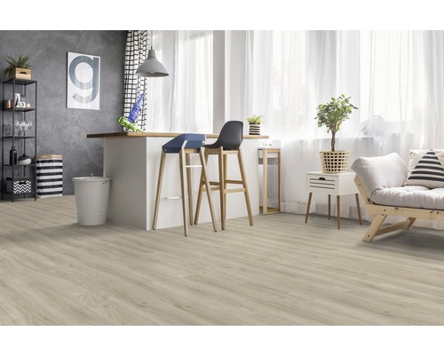 Heller Raum mit hellem Holzboden, Kücheninsel, Barhockern und Sofa.