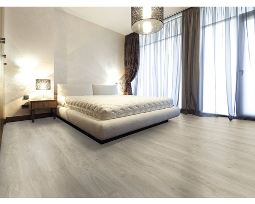 Heller Schlafzimmerraum mit Bett, Nachttisch und Laminatboden