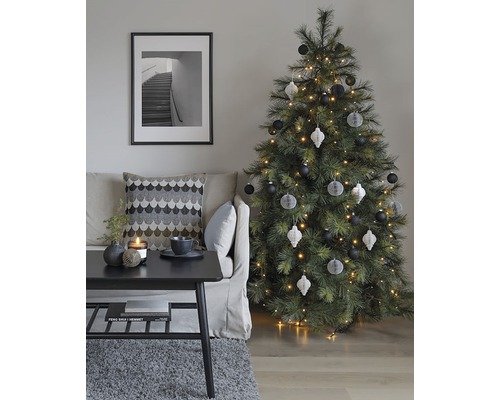 Dekoratives Wohnzimmer mit Weihnachtsbaum, Sofa, Tisch und gerahmtem Bild