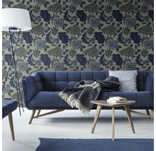 Wohnzimmer mit Sofa, Tisch, Stehlampe und floral gemusterter Tapete