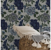 Nahaufnahme einer floralen Tapete mit Kissen und Decke in einem geflochtenen Korb.