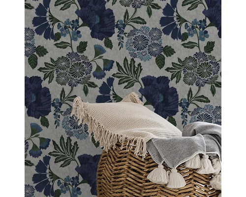 Nahaufnahme einer floralen Tapete mit Kissen und Decke in einem geflochtenen Korb.