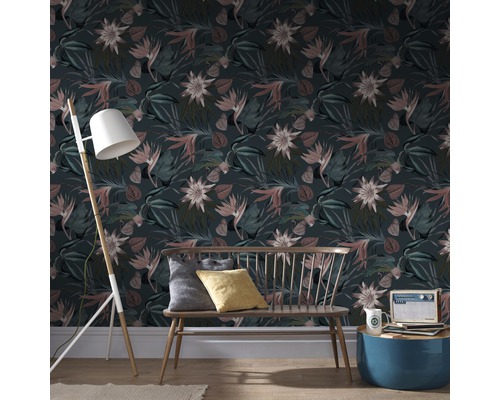 Wohnzimmer mit floral gemusterter Tapete, Bank, Stehlampe und Beistelltisch.