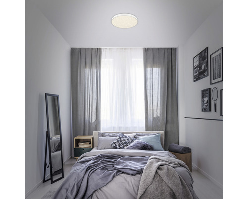 Chambre avec plafonnier, lit et miroir