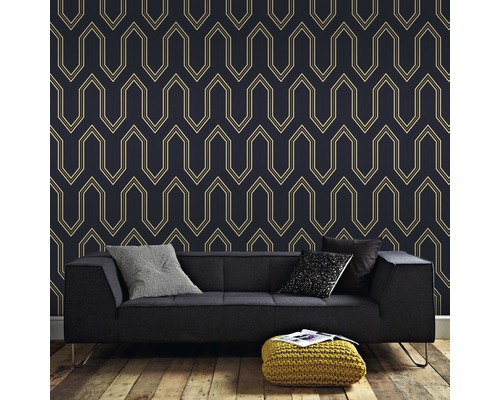 Salon avec papier peint à motifs, canapé, coussins et pouf
