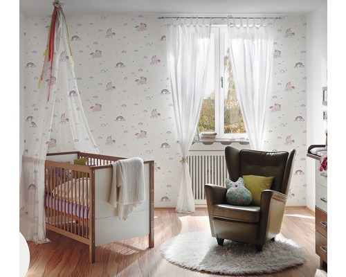 Chambre d''enfant avec lit à barreaux, fauteuil et papier peint à motif de licorne