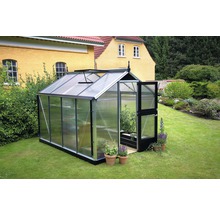 Gewächshaus mit geöffneter Tür und Pflanzen im Garten