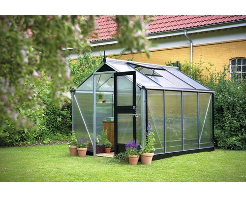 Serre dans le jardin avec porte ouverte et plantes en pot