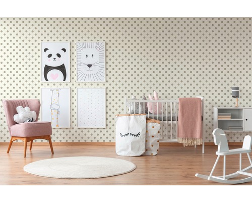 Helles Kinderzimmer mit gepunkteter Tapete, Kinderbett, Sessel und Spielsachen