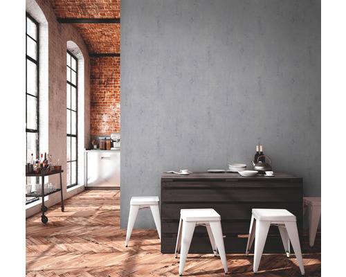 Pièce lumineuse avec parquet, mur en briques et mur gris