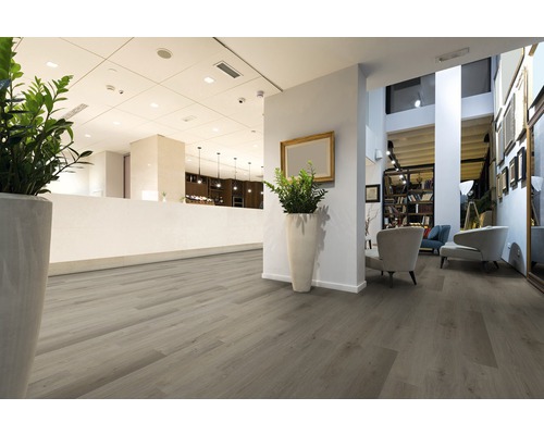 Intérieur avec plancher en bois clair, coin salon et comptoir d''accueil