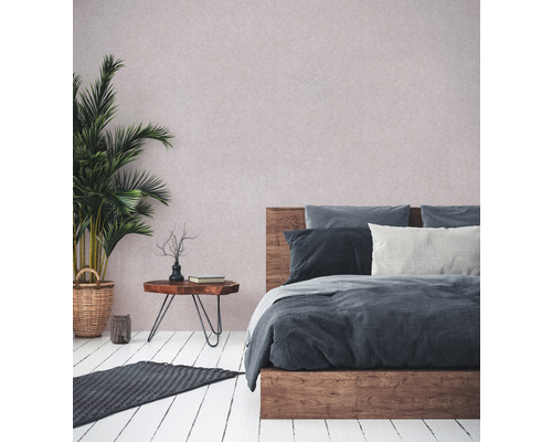 Schlafzimmer mit Bett, Beistelltisch, Zimmerpflanze und Teppich