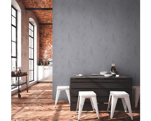 Helles Zimmer mit Holzboden, Backsteinwand und minimalistischer Einrichtung mit Tisch und Hockern