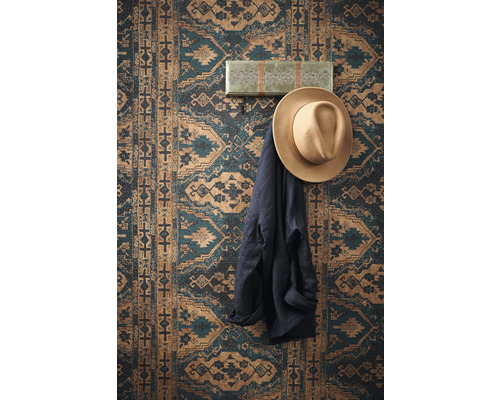 Dekorative Wand mit gemustertem Tapetenmotiv, Hut und Jacke an einer Wandgarderobe