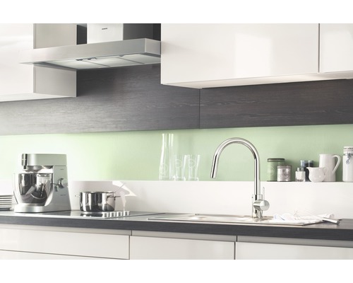 Scène de cuisine avec robinet de cuisine, évier, plaque de cuisson, hotte aspirante et appareils de cuisine.