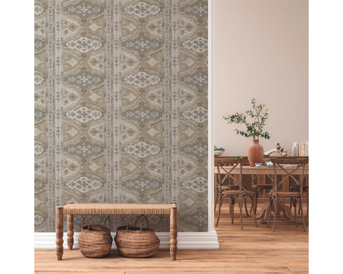 Intérieur avec papier peint à motifs, banc en bois et salle à manger avec table et chaises en bois.