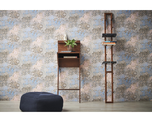 Zimmeransicht mit einem Stehpult, einem Regal und einem Pouf vor einer gemusterten Tapete