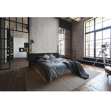 Chambre lumineuse avec lit, tapis et grande fenêtre de style loft