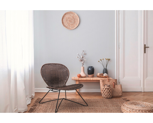 Wohnzimmer mit Rattansessel, Holzbeistelltisch und Dekoration