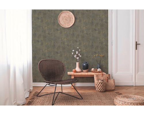 Salon décoratif avec papier peint à motifs, fauteuil, table et tapis pour une ambiance chaleureuse.