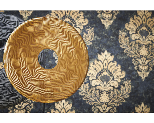 Disques décoratifs à la structure ondulée devant un mur à motifs floraux.