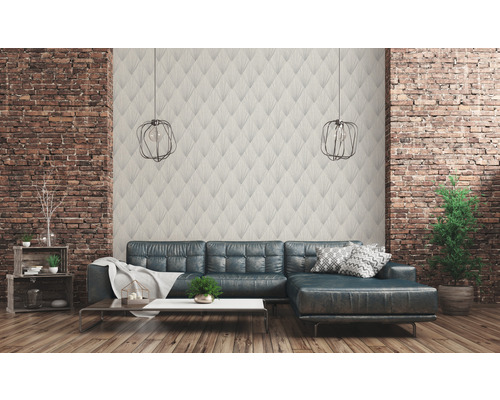 Wohnzimmer mit gemusterter Tapete, Ledersofa und dekorativen Elementen vor einer Ziegelwand