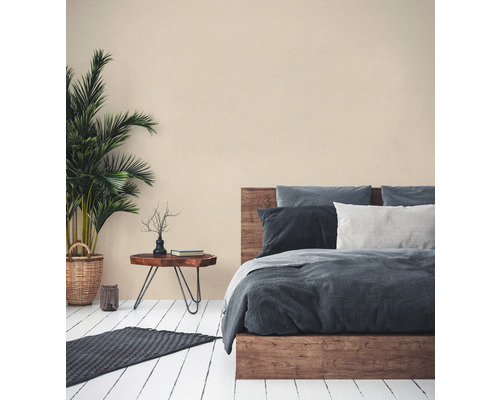 Schlafzimmer mit Holzbett, Beistelltisch, Zimmerpflanze und Teppich auf Holzboden