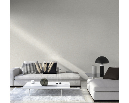 Wohnzimmer mit Sofa, Tisch und Dekoration vor einer hellen Wand