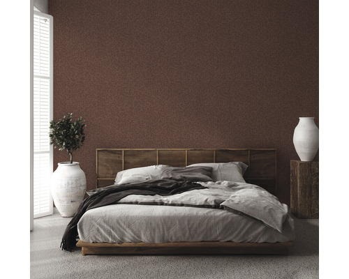 Chambre à coucher avec papier peint à motifs bruns, lit, table de chevet et plante d''intérieur