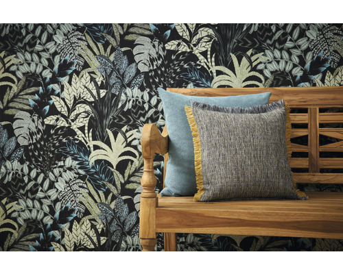 Dekorative Kissen auf einer Holzbank vor einer Wand mit Blattmuster-Tapete.