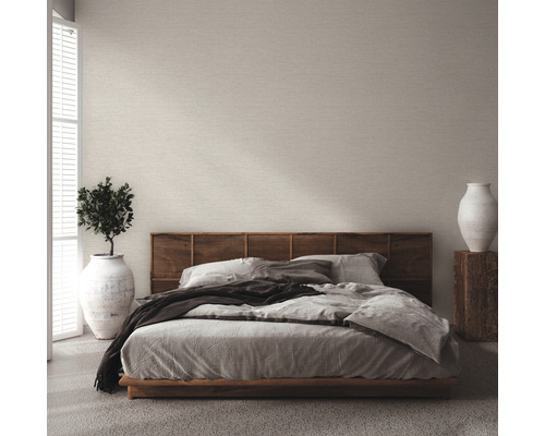 Schlafzimmer mit Bett, Holzkopfteil und hellfarbiger Tapete