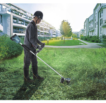 Eine Person benutzt einen Akku-Rasentrimmer von Makita im Freien.