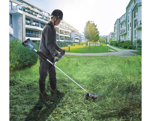 Eine Person benutzt einen Akku-Rasentrimmer von Makita im Freien.