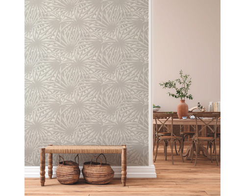 Espace de vie avec papier peint à motifs, parquet et bancs en bois avec paniers.