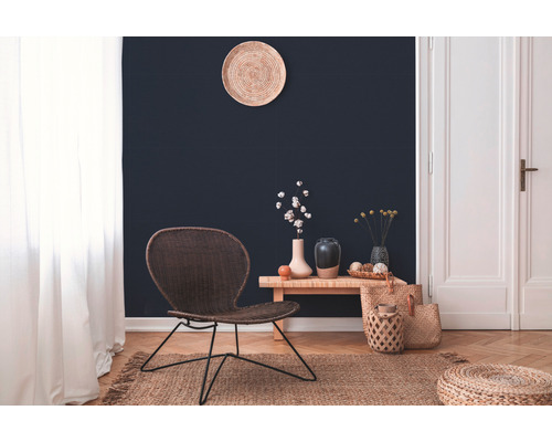Salon avec chaise tressée, table d''appoint en bois et accessoires décoratifs sur un tapis