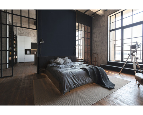 Chambre de style loft avec lit, fenêtres et coin cuisine