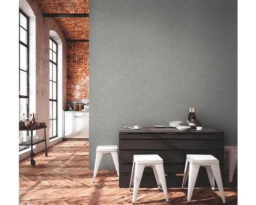 Wohnraum mit grauer Wand, dunklem Holztisch und weißen Hockern