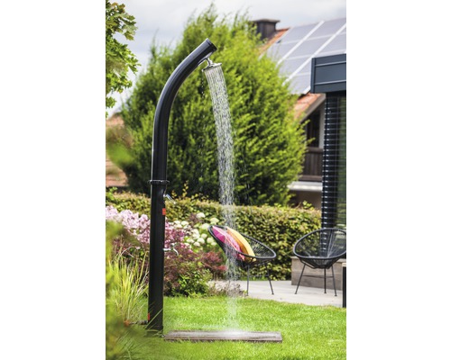 Scène de jardin avec douche extérieure, pelouse et mobilier de jardin
