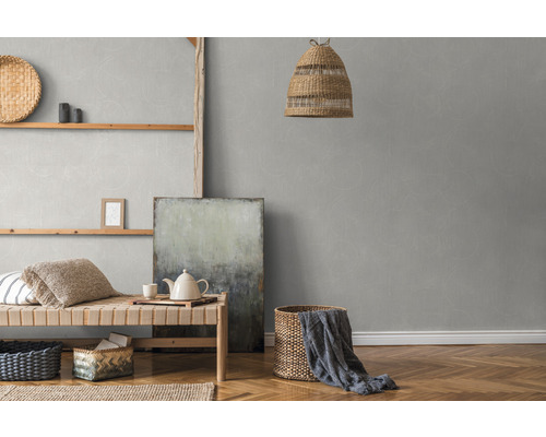 Pièce lumineuse avec une lampe en rotin, une étagère murale et du papier peint gris