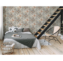 Une chambre avec un lit, une chaise et un escalier devant un papier peint mural à motifs de taches.