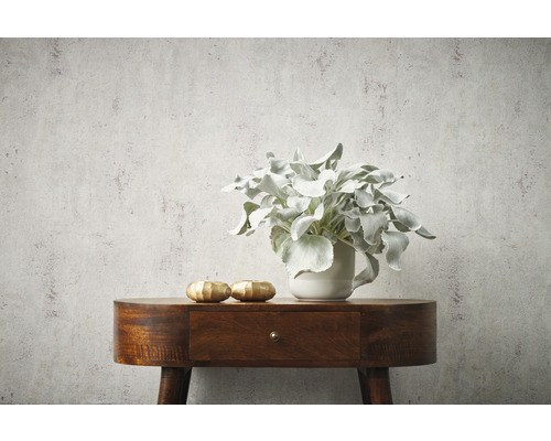 Nahaufnahme einer Kommode mit Dekoration und einer strukturierten Tapete im Hintergrund.