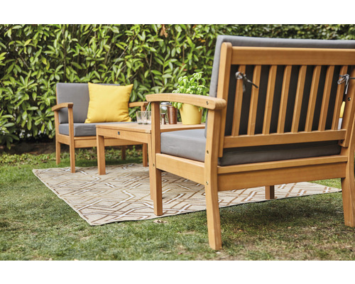 Gartenmöbelset aus Holz mit Kissen auf einem Teppich im Freien