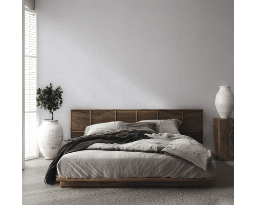 Schlafzimmer mit Bett, Holzkopfteil, Pflanze und Vase