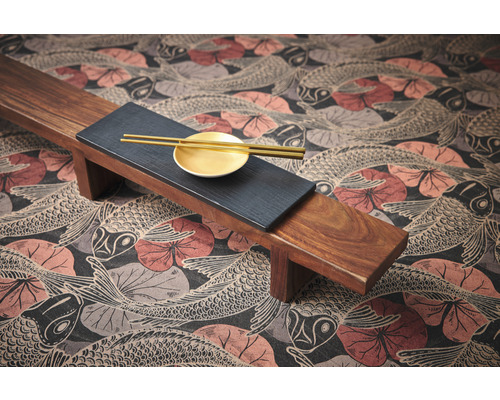 Esstischdekoration mit Holztablett, Teller und Essstäbchen auf einer Tischdecke mit Fischmuster