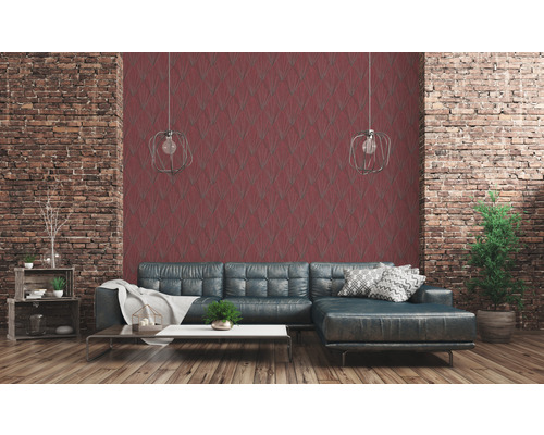 Salon avec mur de briques, papier peint à motifs rouges et canapé gris